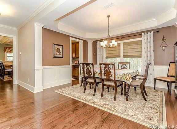 Elegant Formal Dining Room features a trey ceiling & wainscoting