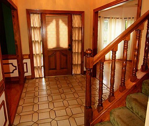 Two Story Entry and view of front door and all the beautiful woodwork home offers.