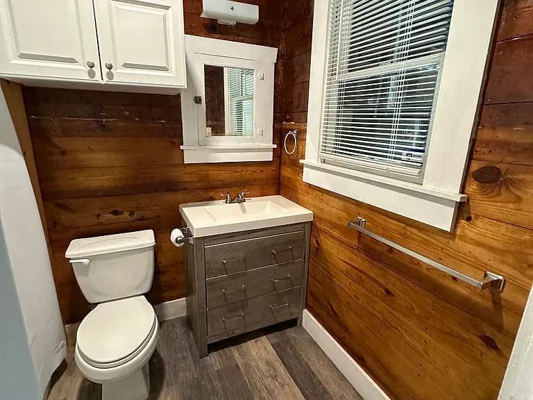 Bathroom with beautiful original wood accent walls and vintage medicine cabinet.