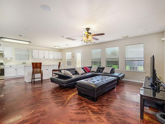 Large Open Concept Living Room on the first floor with stylise stained floors.