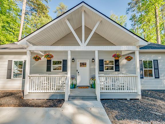 Welcoming front entrance with vibrant pops of color from hanging and potted plants, creating a cheerful and inviting curb appeal.