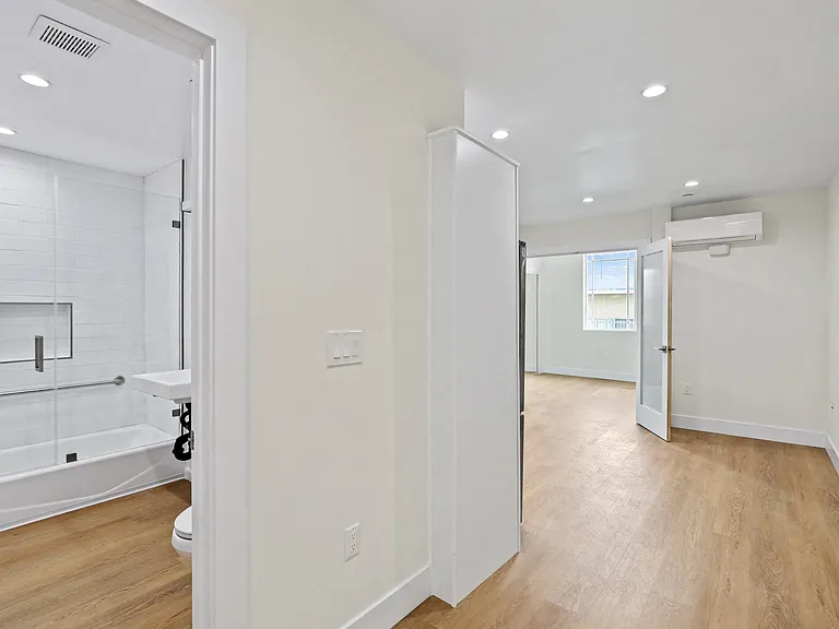 Unit with Vinyl Flooring and Hall Bathroom with Full-Size Bathtub