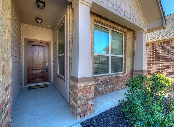 A charming entryway and well-manicured flower beds welcome you to the home.