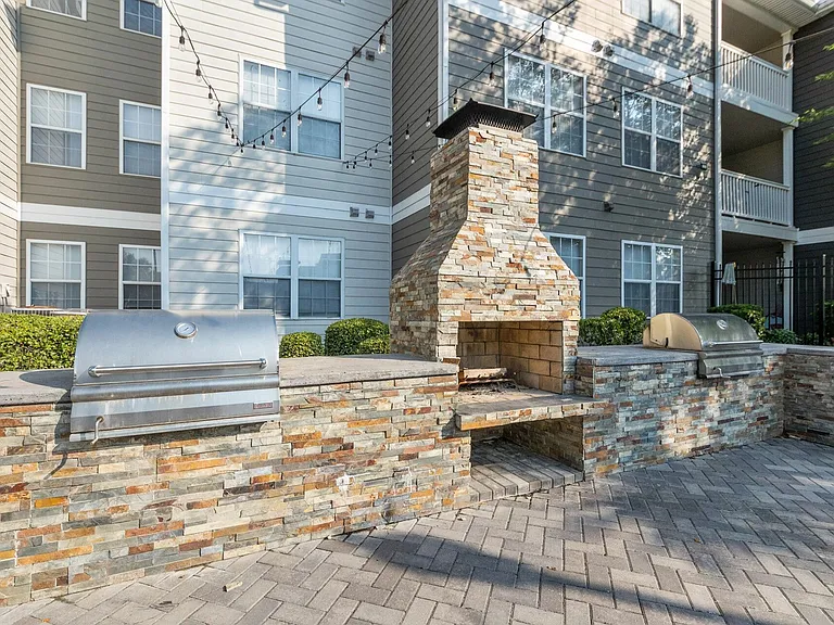 Outdoor Kitchen with Stone Counters, BBQ Grills, and Wood-Fired Oven at Theater Street Apartments