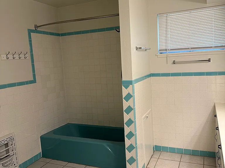 Main bathroom features a shower/tub combination and ample storage.