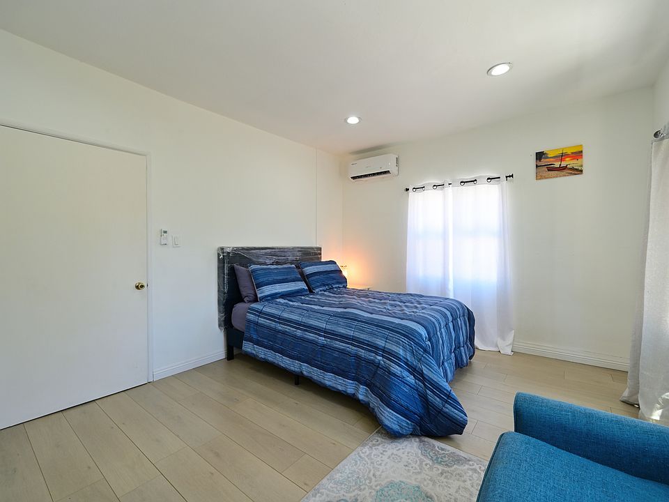Super spacious bedroom furnished with TV, queen bed and mattress, mini split AC, Loveseat and Coffee table - with views of PCC