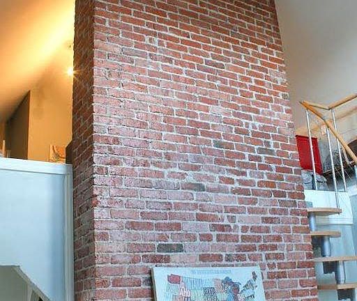 Exposed brick fireplace in 2 story living room