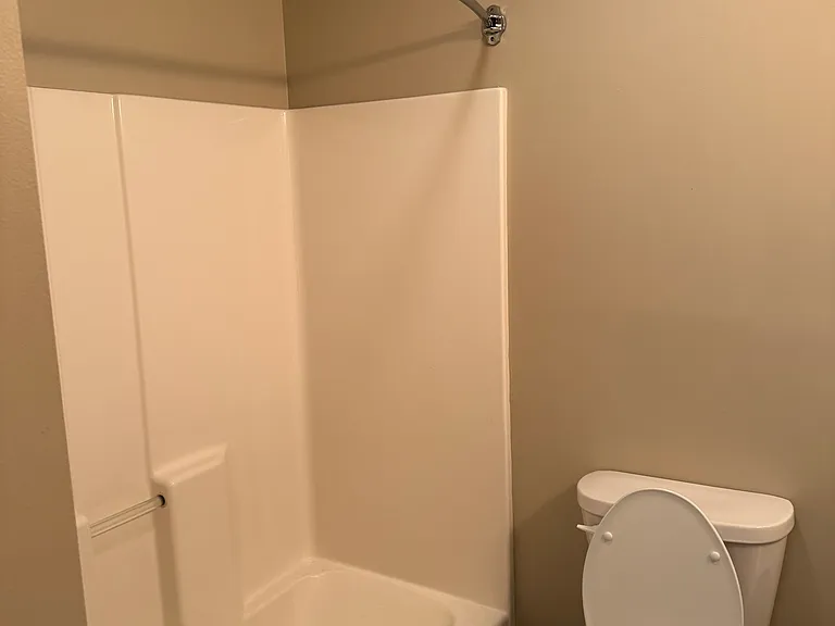 Full size shower with tub and high-seat toilet.