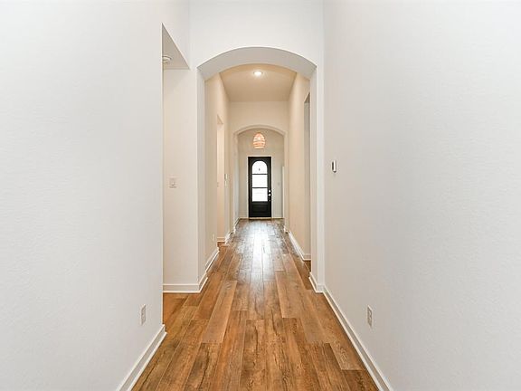 Looking toward the front entry you will notice hallways to either side. The secondary bedrooms, bathrooms and laundry room are nicely separated from the living area and primary bedroom, to allow for great privacy.