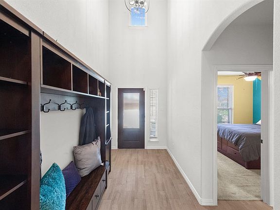 Mudroom featuring light hardwood / wood-style flooring, ceiling fan, and a towering ceiling