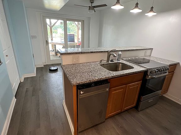 Photo of the kitchen, living room and view of outside. Utilities included: electric, water, sewer, internet!