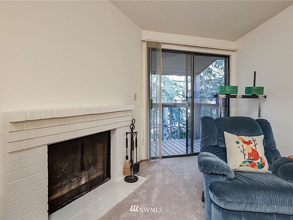 The living room geatures a wood-burning fireplace, and access to the balcony deck, which is covered for all-weather year-round enjoyment.