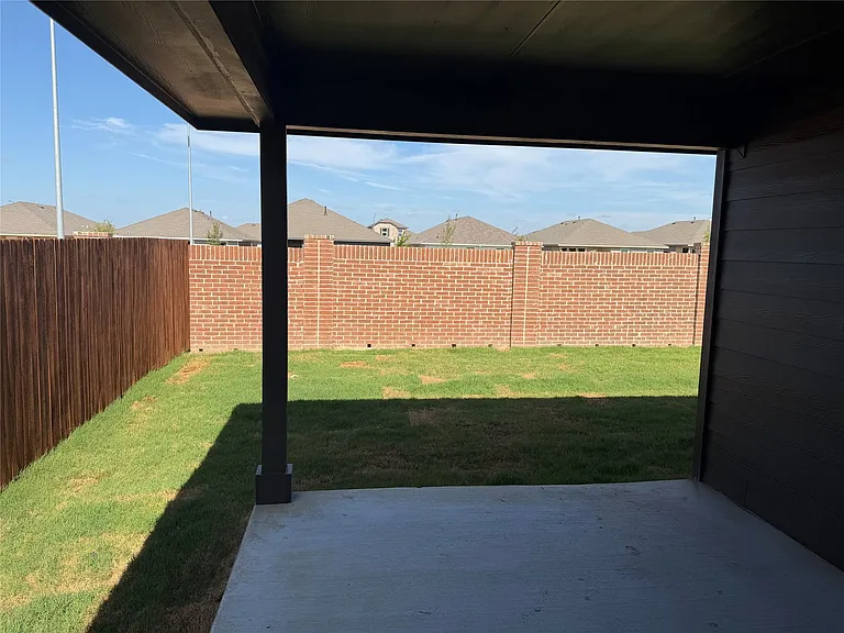 Covered patio featuring a concrete slab and a dark ceiling