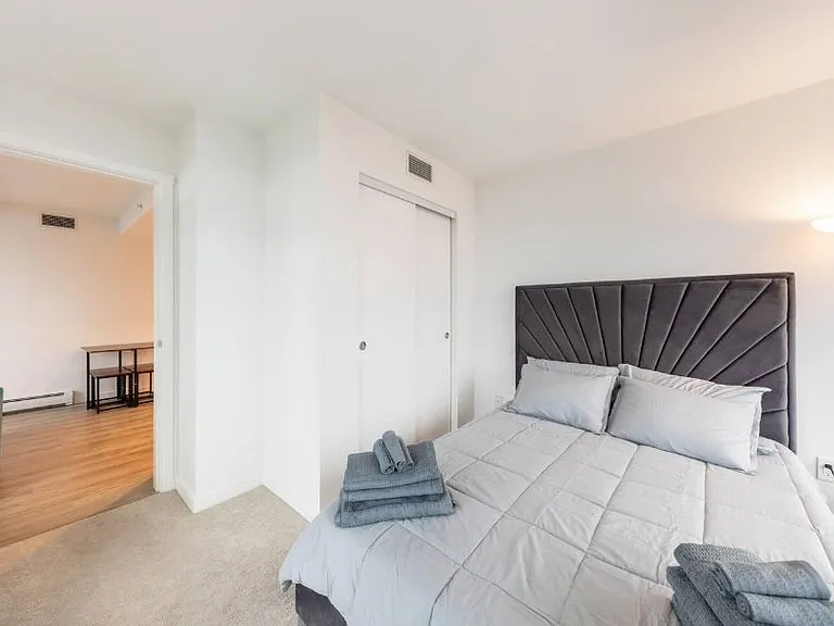 A vibrant view from the bed, complemented by a stylish stand lamp, creating a cozy and inviting atmosphere.