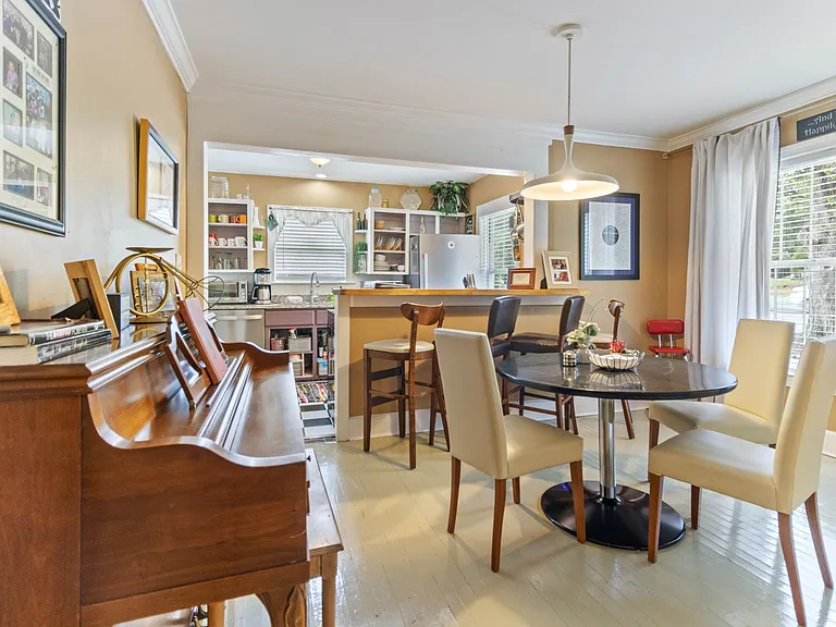 Dining room at Hunsucker's place with piano and looking into the Kitchen all within walking distance of Cone Hospital and Downtown Greensboro