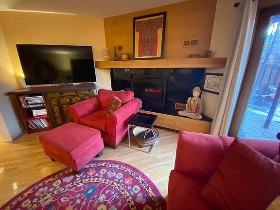 Comfy, furnished living room w/ big tv, electric fireplace, and slider to backyard.