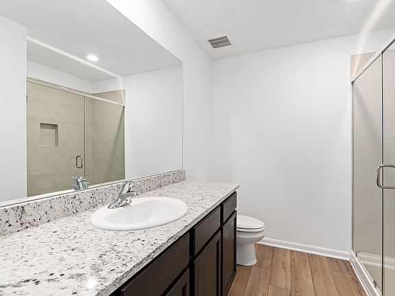 Master bathroom with a walk-in shower and expansive countertops.