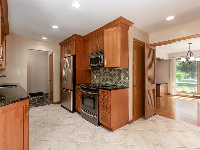 Fully equipped kitchen with stainless steel appliances, granite countertops, soft close natural wood customized cabinets with crown molding.