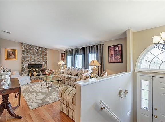 The sun filled entry foyer has custom circle top windows.  The living room is highlighted with a ceiling to floor stone fireplace and cathedral ceilings.
