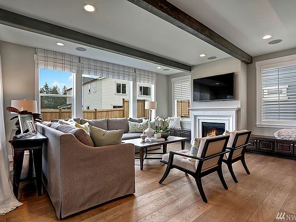Great room with  cozy fireplace and lot of natural light. Photo not of actual home - may contain optional features.