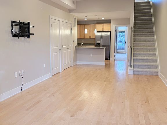 Bright, open-concept living space with hardwood floors, recessed lighting, and seamless flow to the modern kitchen.