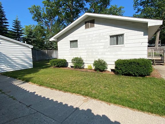 View of the east small side of the house from inside the fenced yard.