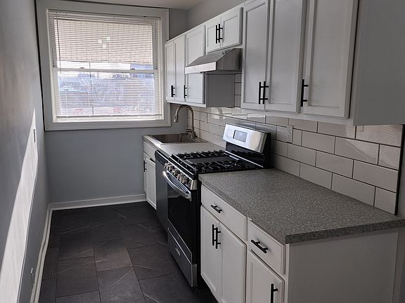 One side of the kitchen. Brand new kitchen floors, counters, stainless steel appliances including dishwasher, lots of cabinet space.