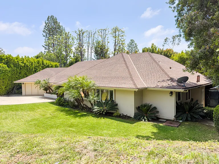 Tropical landscaping and a vibrant green lawn enhance the curb appeal of this Beverly Hills luxury rental at 1094 Garden Lane, 90210.