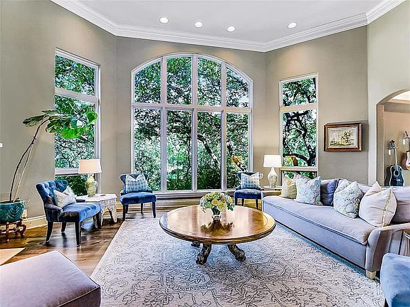 Formal living room with piano, fireplace and beautiful tree views.