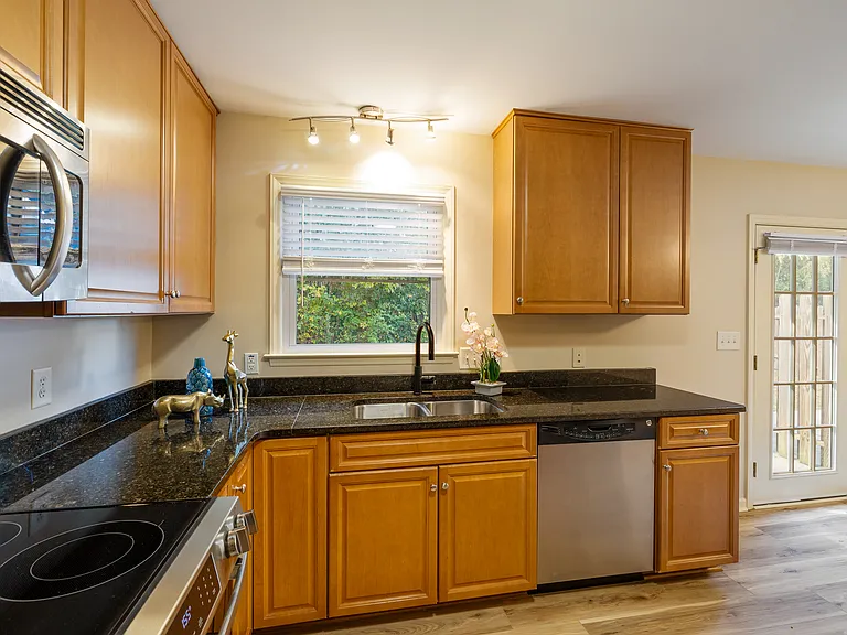 Kitchen; sink window and french doors look out to private backyard and detached garage