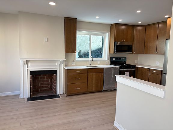 Open kitchen with new cabinetry, quartz countertops and all new appliances. Check out your decorative fireplace too!