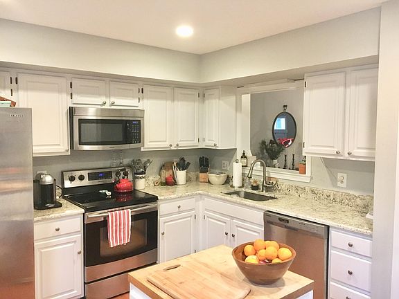 Kitchen with recessed lights, white cabinets, granite counters, undermount sink, spray pull down faucet, stainless steel front appliances, butcher block island