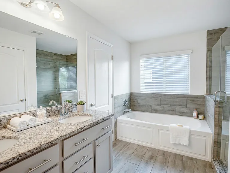 View of bathroom with double sinks and spa tub