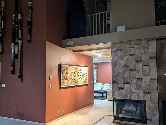 From living room looking at fireplace and den in the background. Overhead is the projection screen for the 100" movie screen