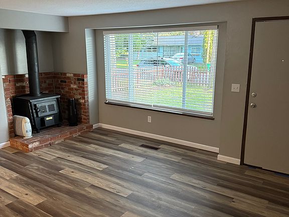 Living room with luxury vinyl floors, new windows, wood burning fireplace/stove.