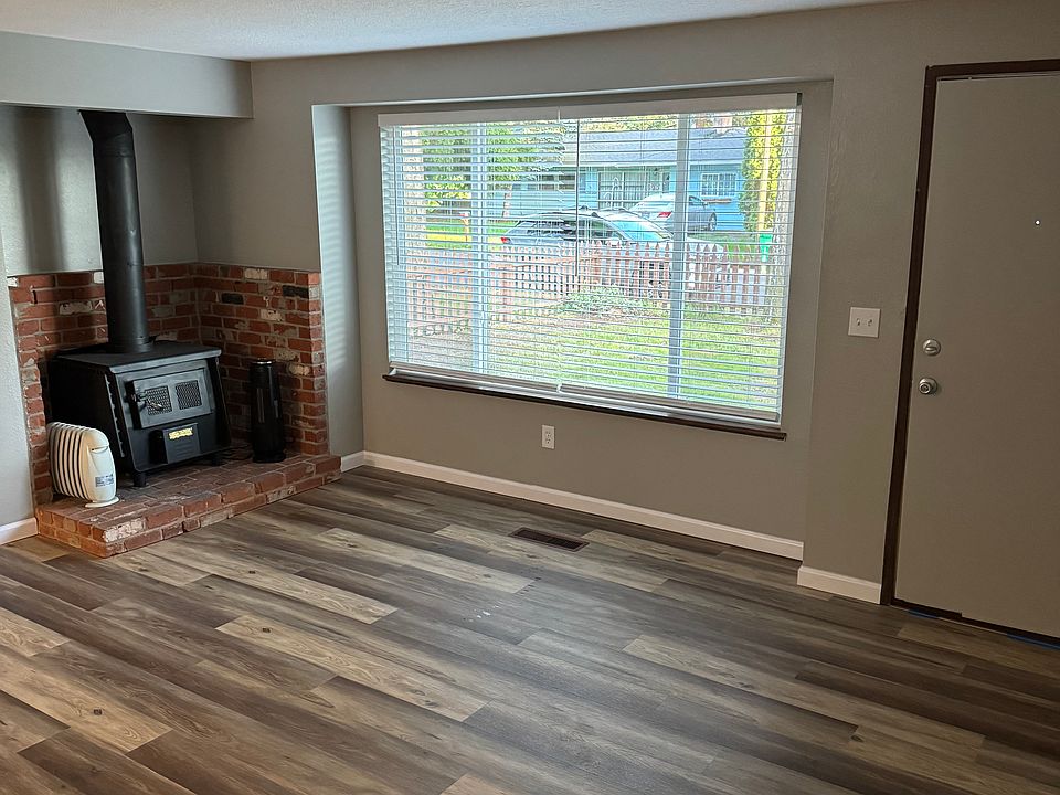 Living room with luxury vinyl floors, new windows, wood burning fireplace/stove.