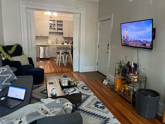 Spacious living room leading into kitchen through pocket doors