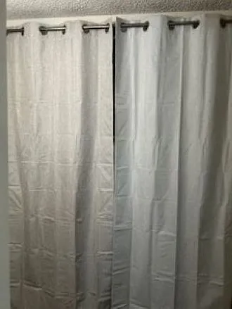 Laundry closet with drapes and rod
