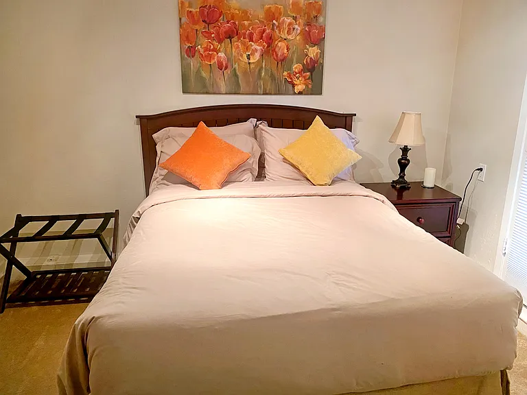 Bedroom features a full-size bed, nightstand, and luggage rack.
Includes a small closet for additional storage.