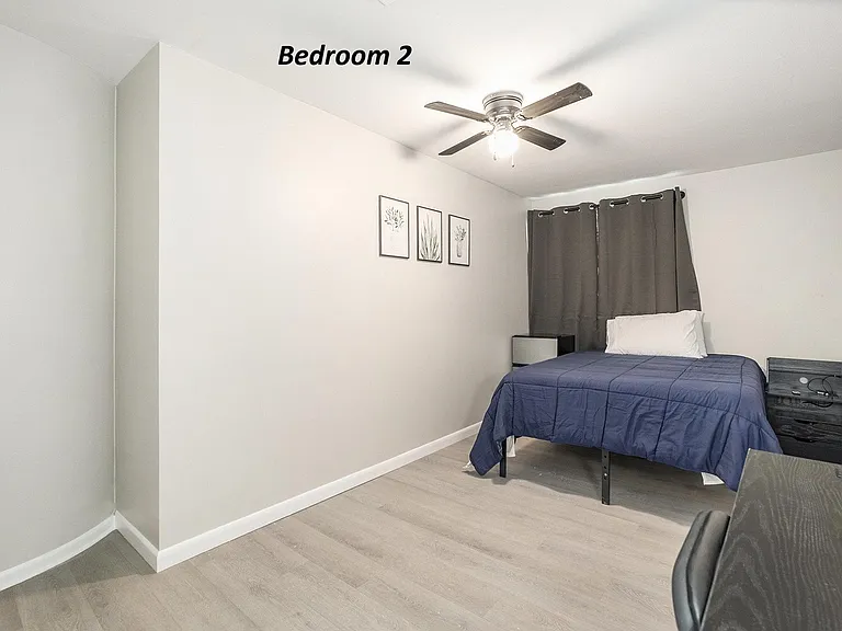 Bedroom 2 with bed, desk, chair, double-door closet & MiniFridge. Bedding may not be provided.