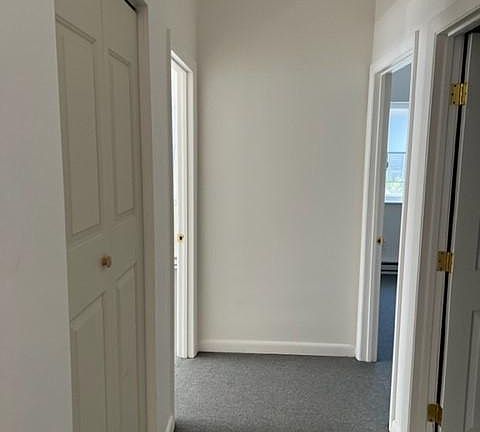 hallway to bedrooms and bathroom with closet