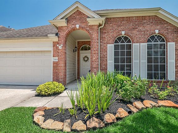 Stone-boarders line the front flower beds with fresh mulch and mature plantings.