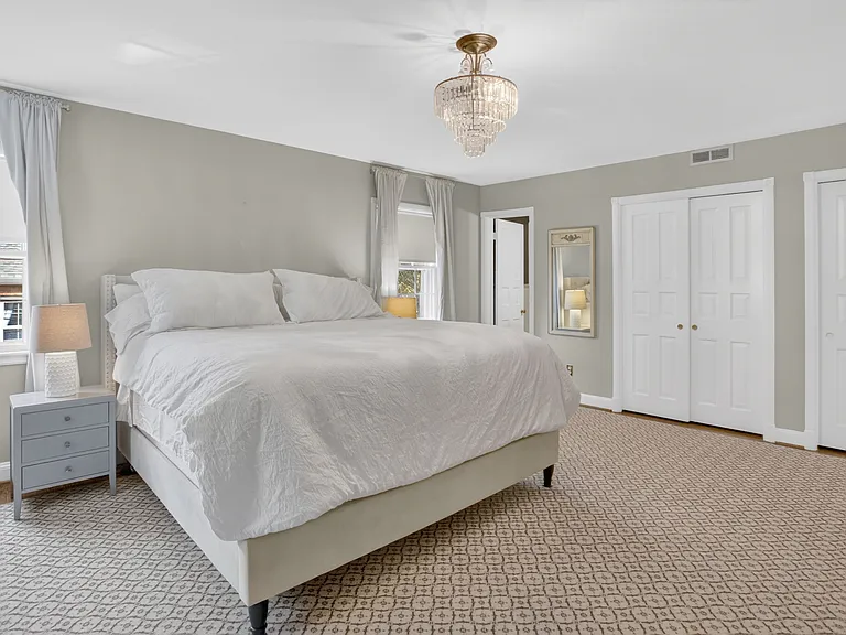 Primary bedroom, hardwood under carpet.