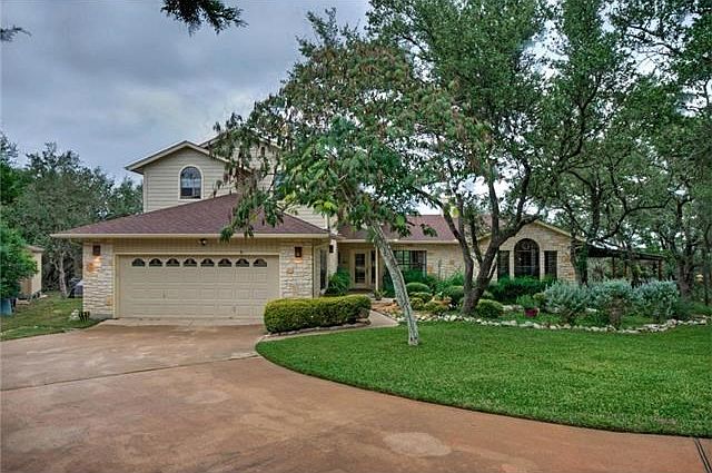 A broad driveway sweeps to the two-car garage and even provides room for guest parking.