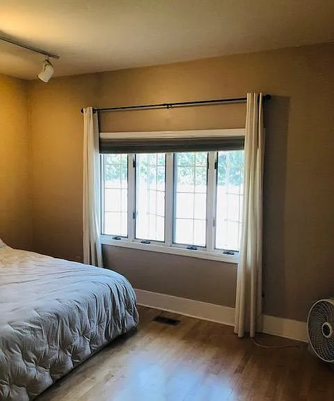 Primary downstairs bedroom facing back yard. So quiet and dark blinds