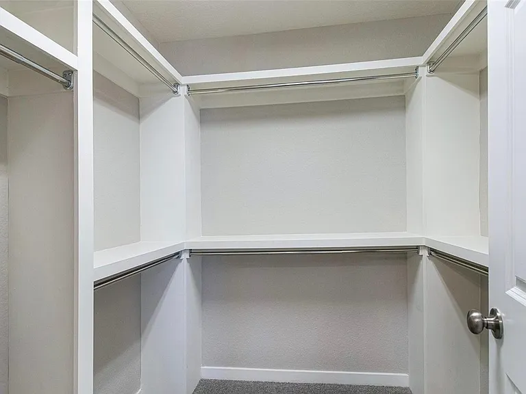 Master bedroom closet with lots of hanging space plus shelves.