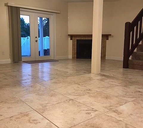 View from kitchen to dinning room and living room with fireplace french doors to fenced in back yard and stairs to second floor