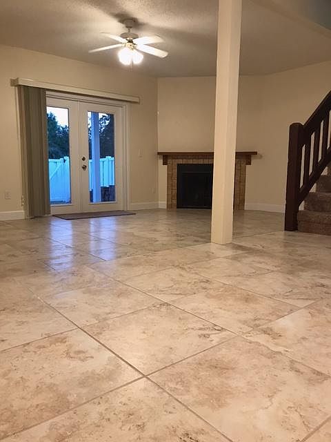 View from kitchen to dinning room and living room with fireplace french doors to fenced in back yard and stairs to second floor