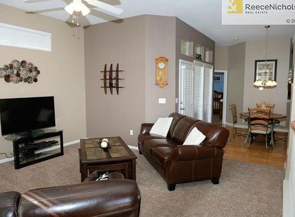 Living room with newer carpets and ceiling fan.