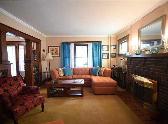 The living room is accented with crown molding, leaded windows, and fireplace.